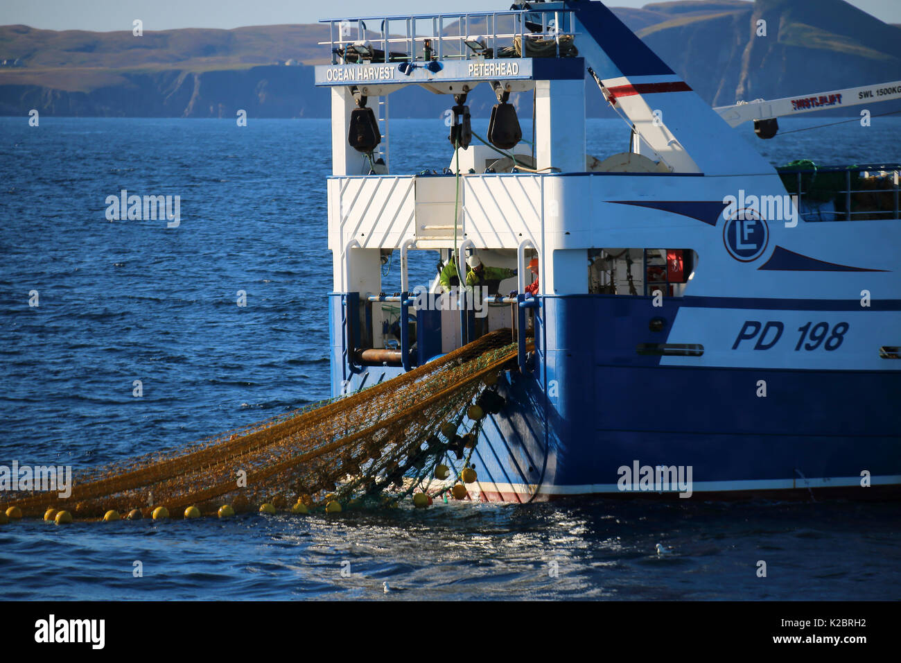 Fishing vessel 'Ocean Harvest' working in calm conditions with Fair Isle in the distance. North Sea, UK, August 2014. Property released.  All non-editorial uses must be cleared individually. Stock Photo