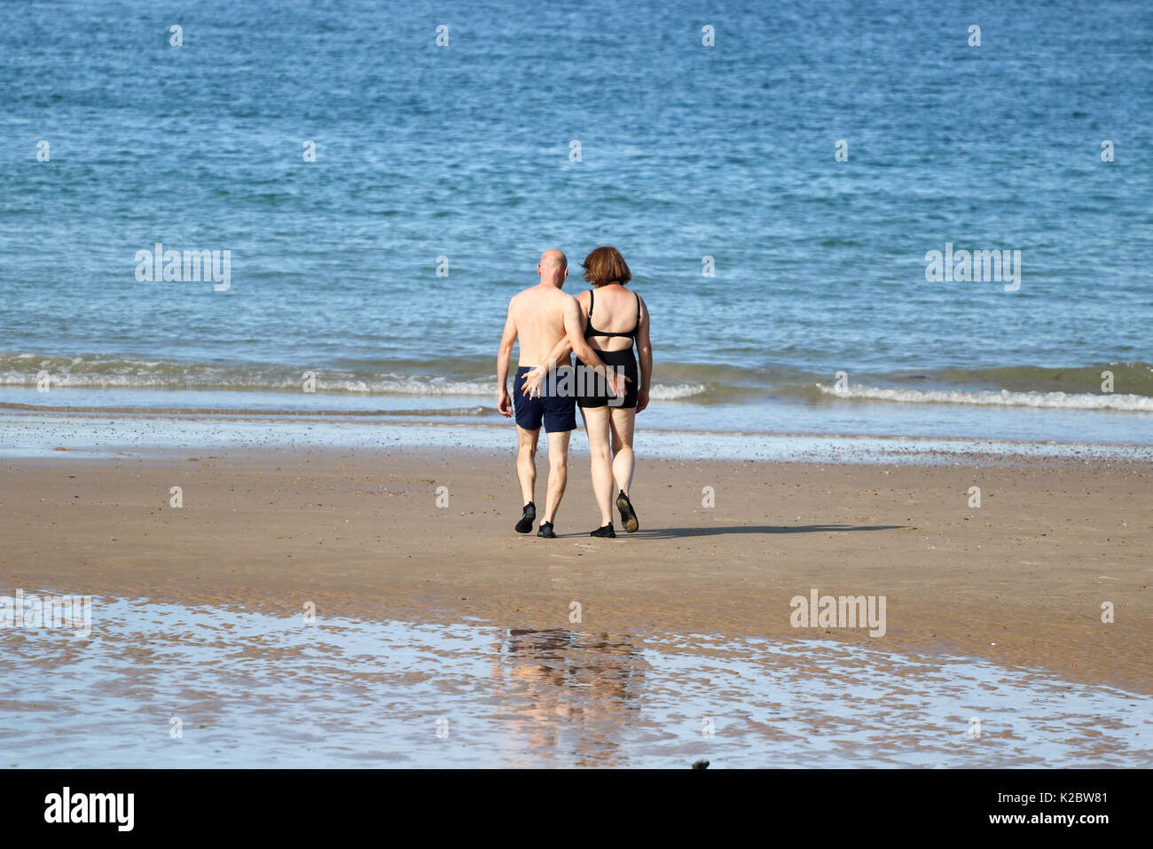 Fifty year old couple walking down to the sea together, Cromer, Norfolk, UK. Stock Photo