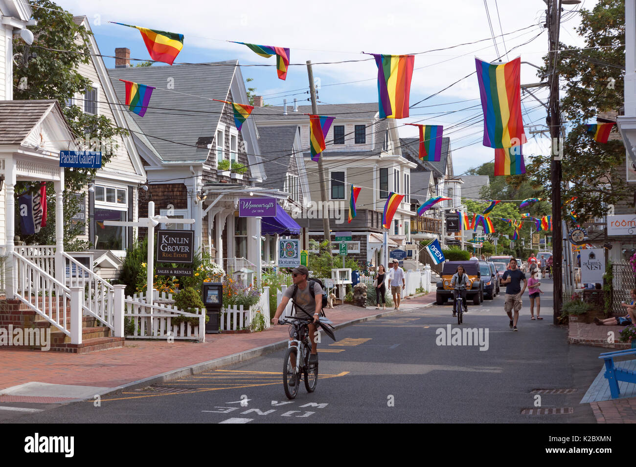 People walking and bicycling on busy Commercial Street in Provincetown, Massachusetts, Cape Cod, USA Stock Photo