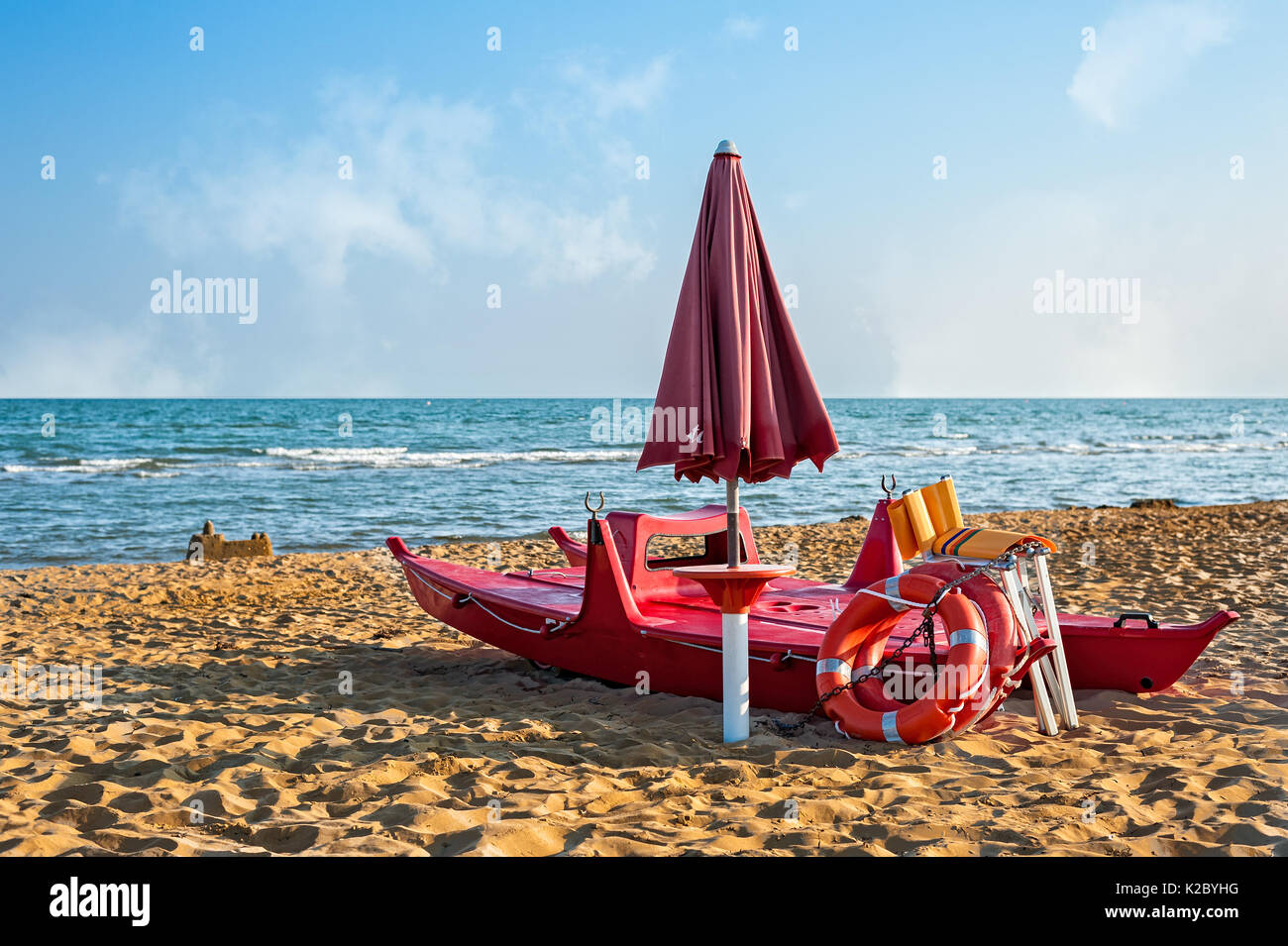 Lifeguard tools, umbrella,lifebuoy and rescue boat against beach,sea and sky Stock Photo