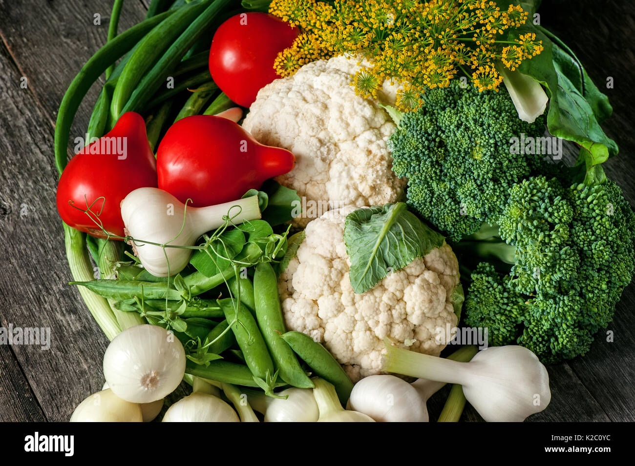Mixed vegetables of cauliflower and broccoli, garlic, green onions, tomatoes and green peas on a
