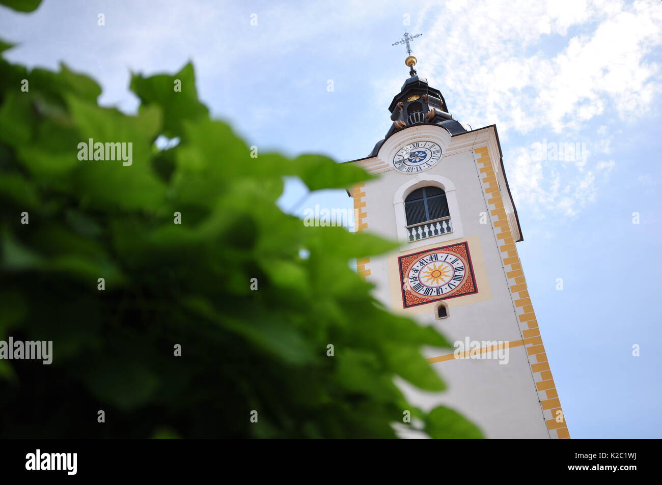 Catholic church bell rising from beyond the trees Stock Photo