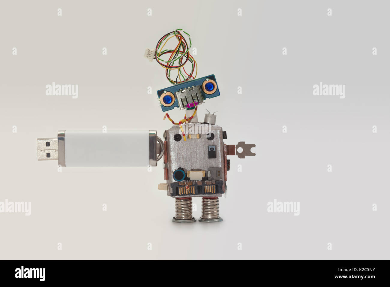 Robot with usb flash storage stick. Data storing concept, abstract computer  character blue eyed head, electrical wire hairstyle. Copy space, gradient  white gray background Stock Photo - Alamy