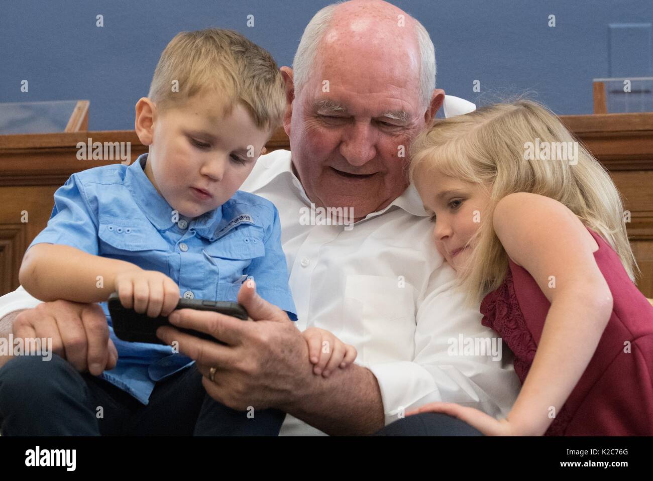 U.S. Agriculture Secretary Sonny Perdue takes a break from his first day on the job to play with his grandchildren at the U.S. Department of Agriculture Headquarters April 25, 2017 in Washington, DC. Stock Photo