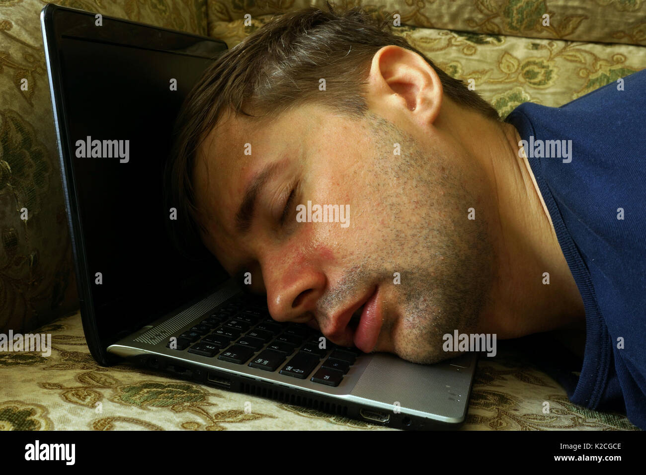 Overworked freelancer sleep on a laptop. Stock Photo