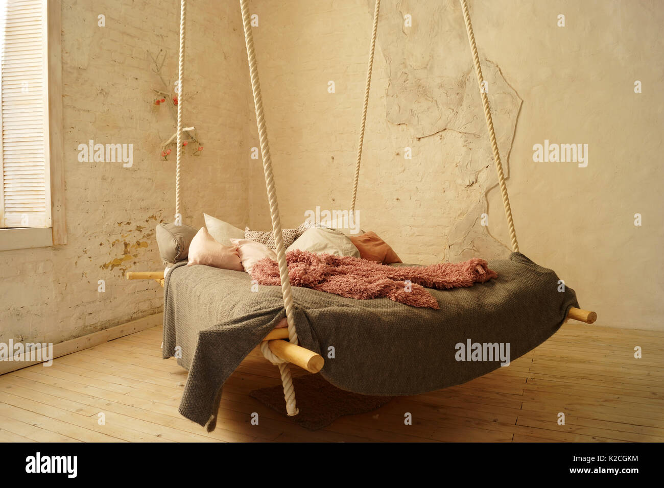 Hanging bed in rural or loft bedroom interior. Stock Photo