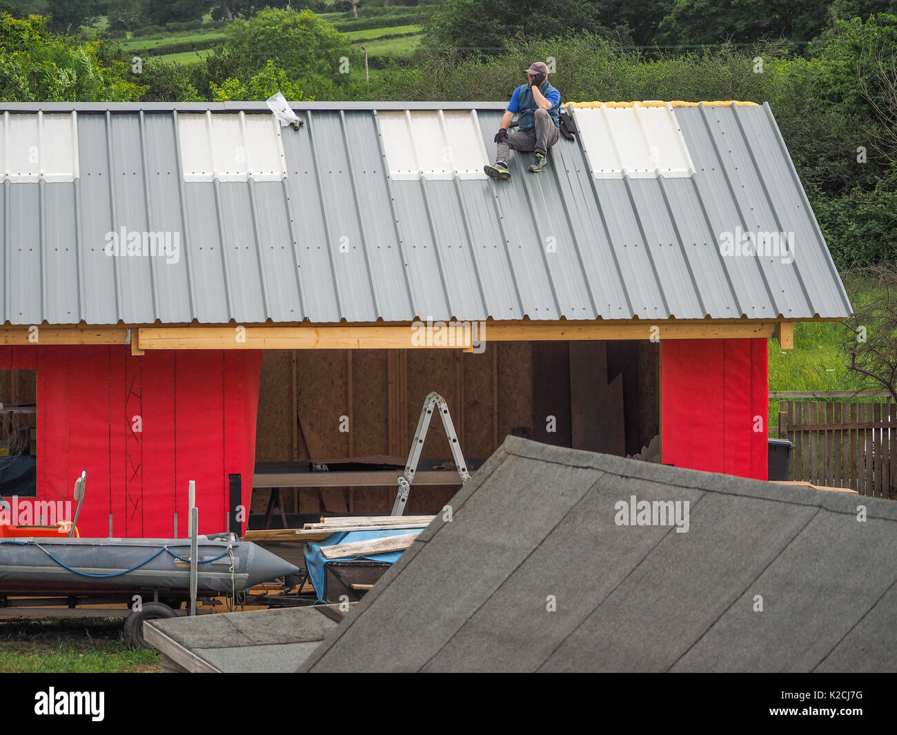 a builder roofer on steel roof construction working at height