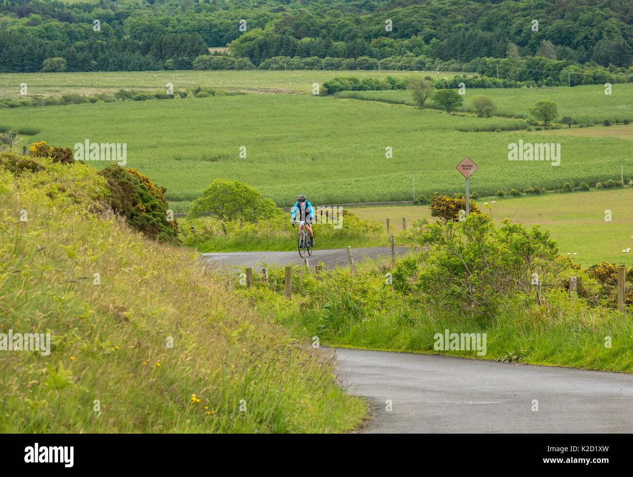 Lone cyclist cycling up Dreva Hill, Cycle Law Scotland Skinny Tweed