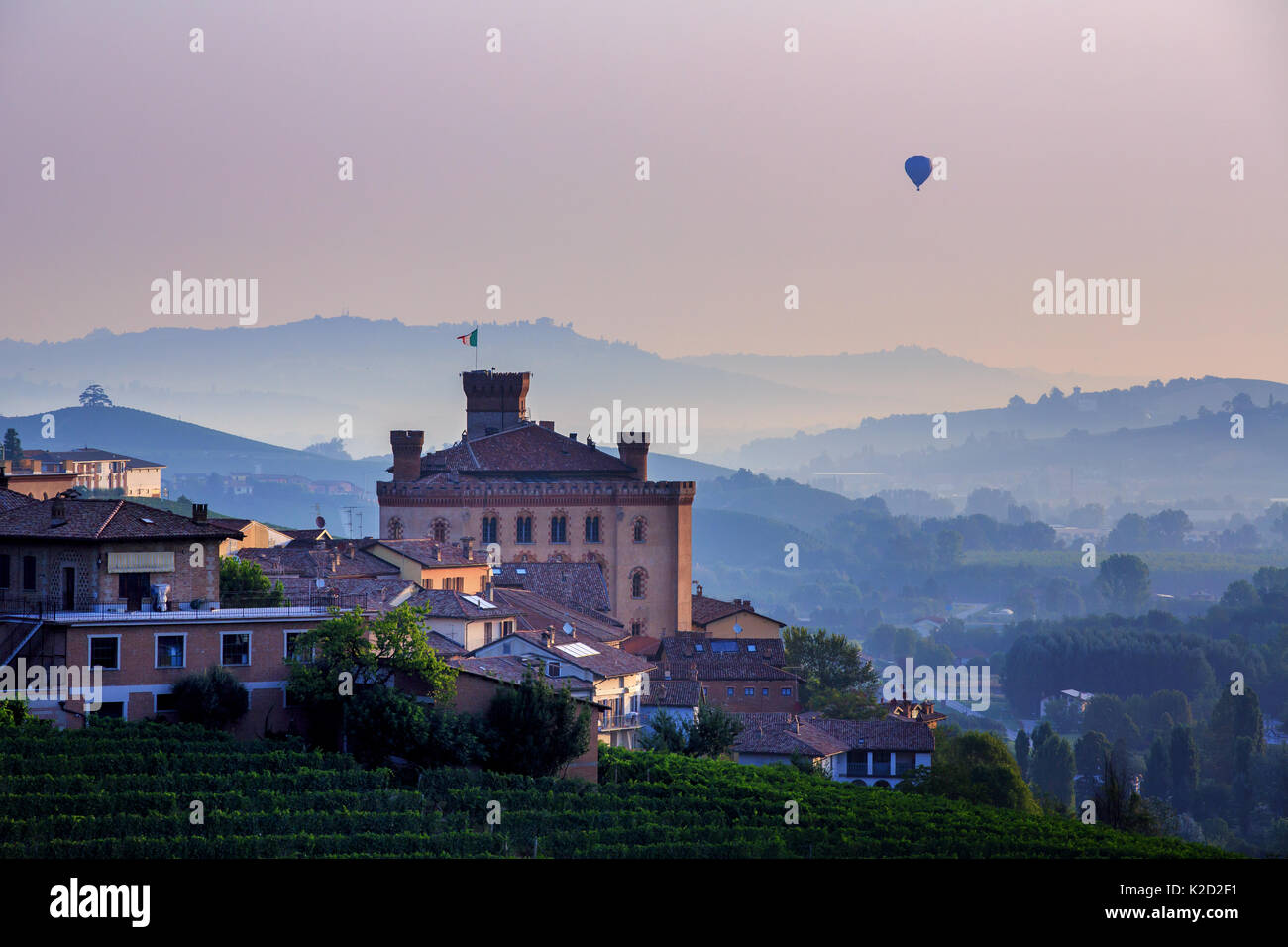 Hot air balloon over the village of Barolo at sunrise, Piedmont, Italy Stock Photo