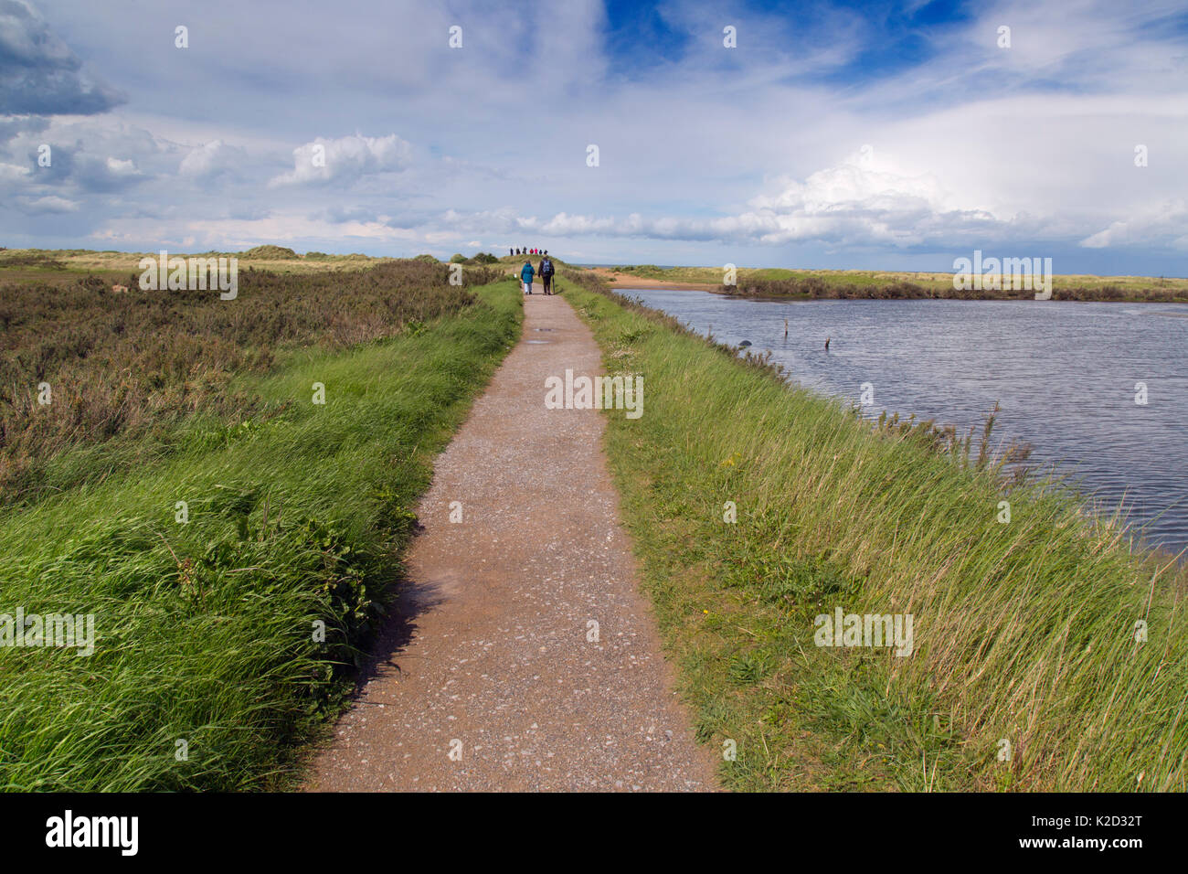 People walking along coastal path at at RSPB Titchwell Nature Reserve, Norfolk, UK, May 2015. Stock Photo