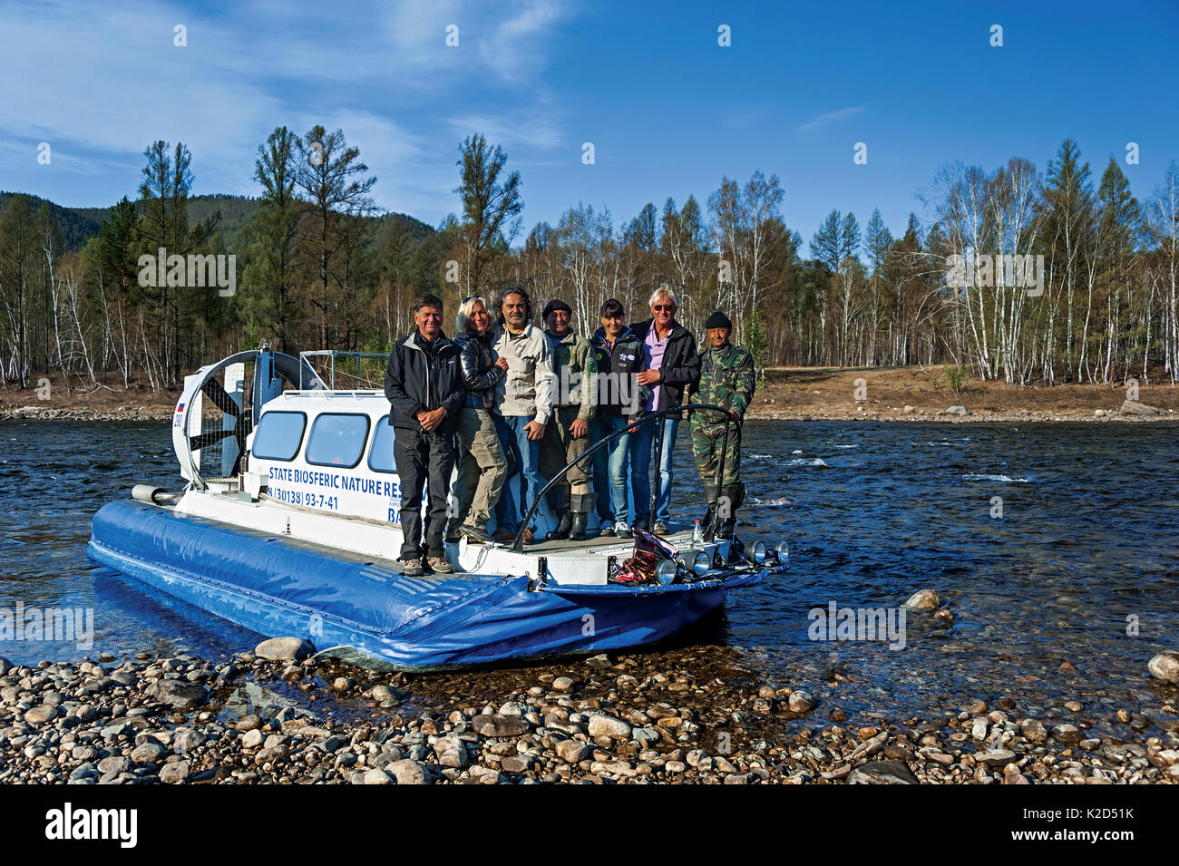 Photographer Michel Roggo on location for his Freshwater Project, standing next to Olga Kamenskaya and  Dimitry Melamed on small boat, Temnik River, Lake Baikal, Baikalsky Reserve, Siberia, Russia. May 2015 Stock Photo