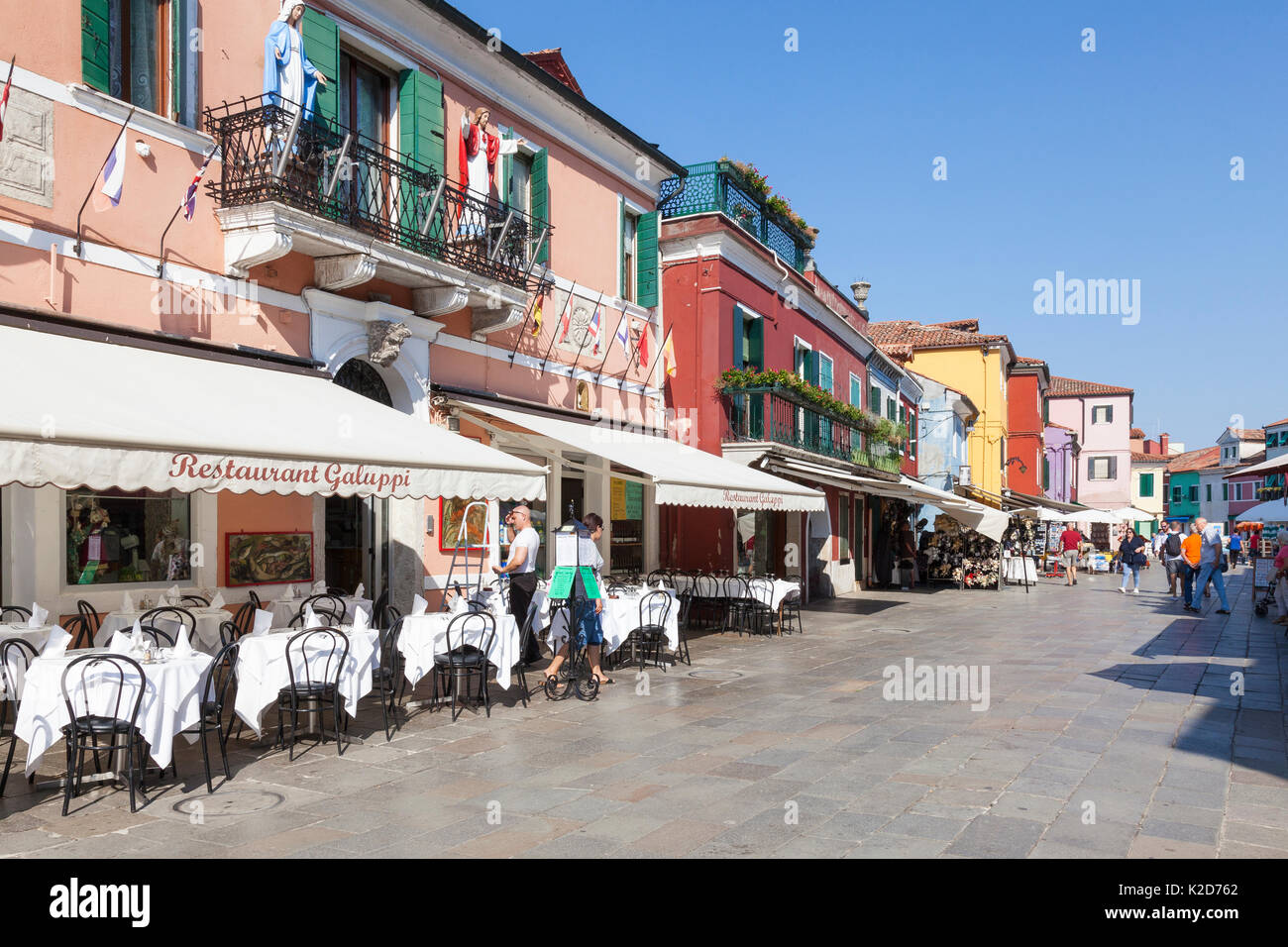 The colorful main shopping area of Burano, Venice, Italy with restaurants , lace shops and souvenir stores . There are a few people walking around but Stock Photo