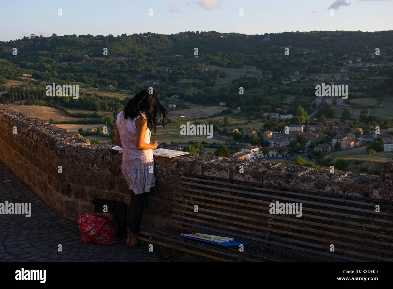 A female painter, painting Orvieto's countryside at sunset from one of Orieto hill panoramic view points. Landscape painting, inspiration from nature Stock Photo