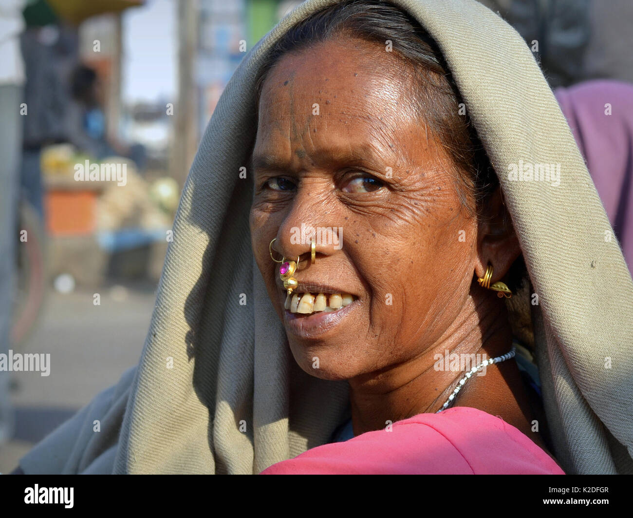 Elderly Indian Adivasi woman (Desia Kondh tribe, Kuvi Kondh tribe) with gold-and-gemstone tribal nose jewellery poses for the camera. Stock Photo