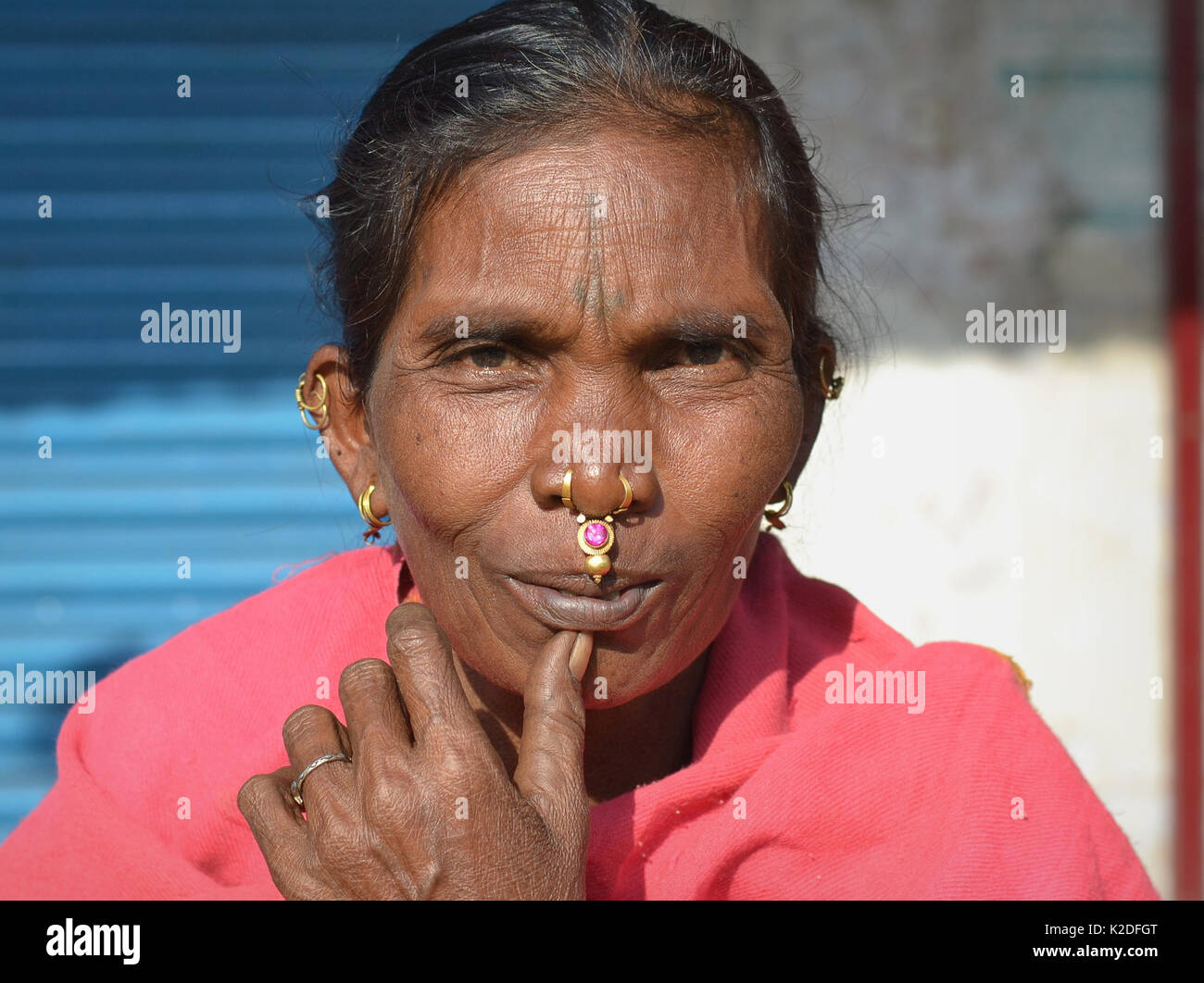 Elderly Indian Adivasi woman (Desia Kondh tribe, Kuvi Kondh tribe) with gold-and-gemstone nose jewellery and tribal earrings smiles for the camera. Stock Photo