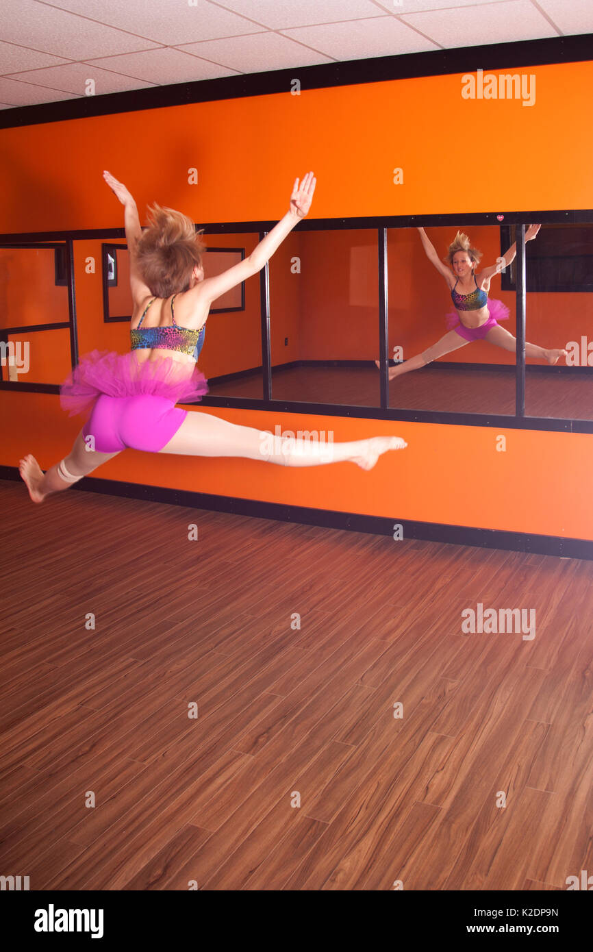 A teenage girl dancer exercising in front of a mirror. Stock Photo