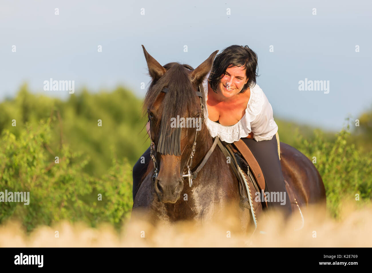 portrait of a mature woman who is sitting on an Andalusian horse Stock Photo
