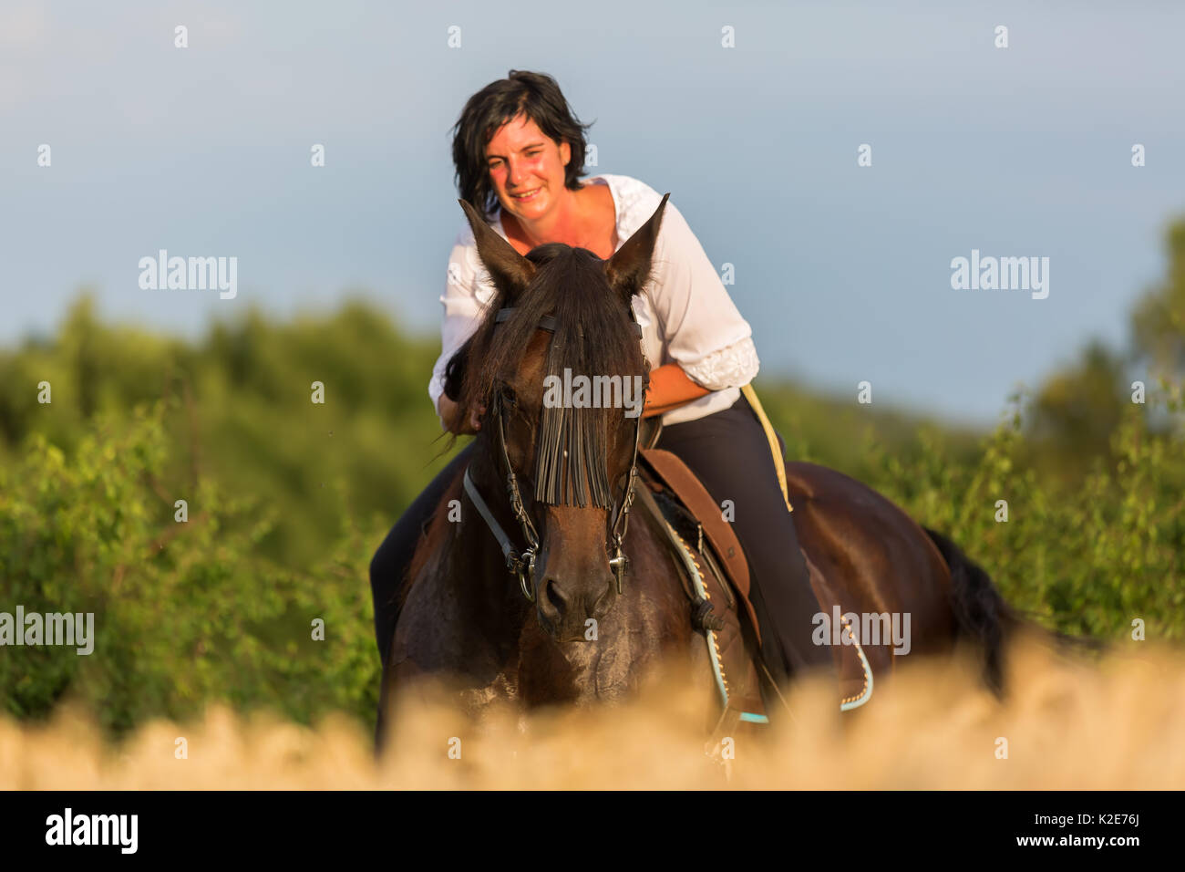 portrait of a mature woman who is sitting on an Andalusian horse Stock Photo