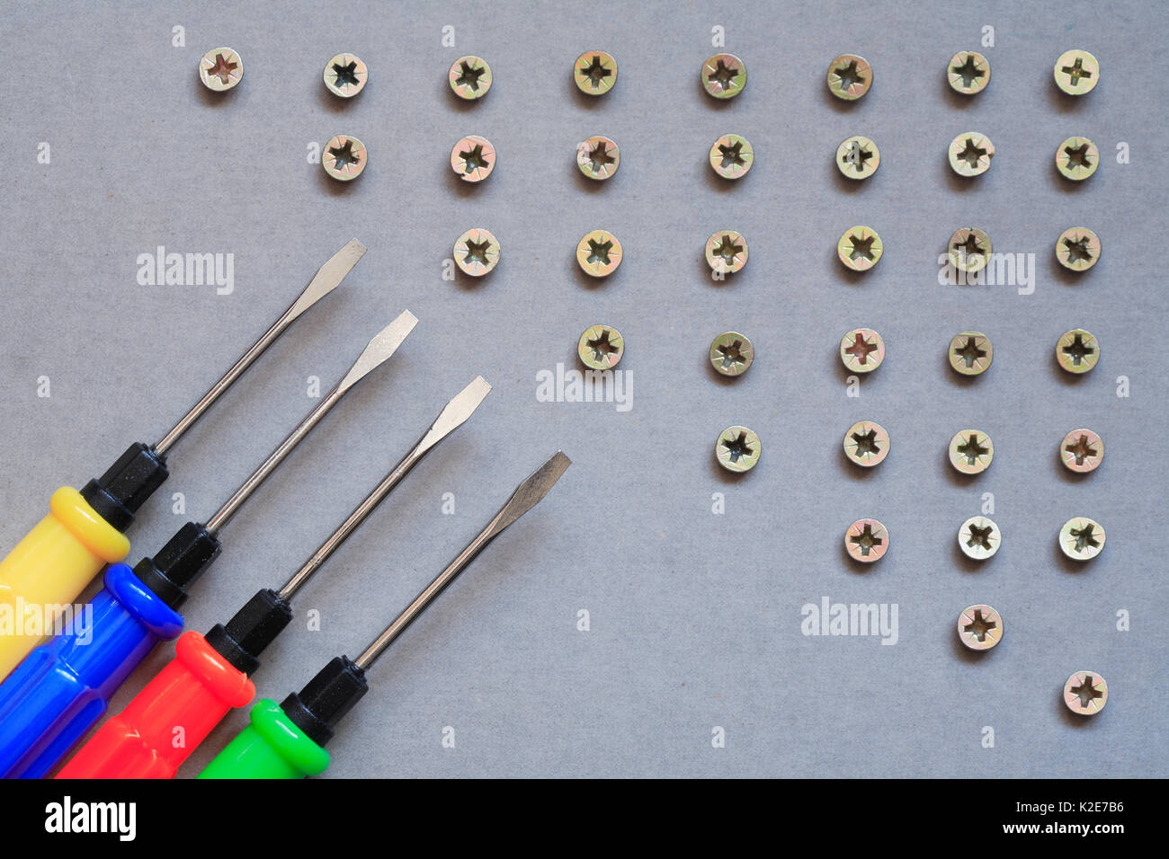 Industrial concept. Set of color screwdrivers near lot of screws Stock ...