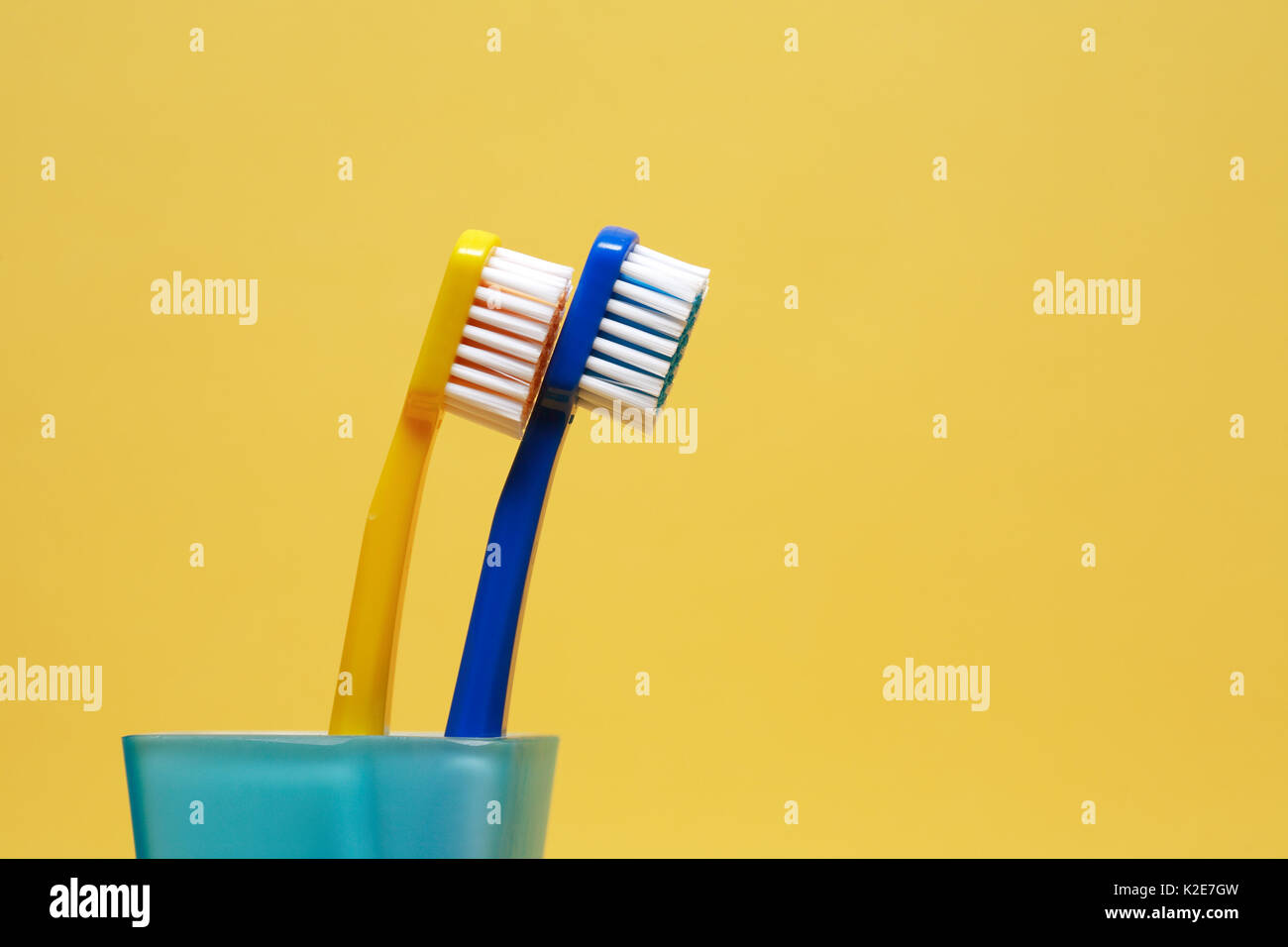 Pair of toothbrushes on yellow background with free space for text ...