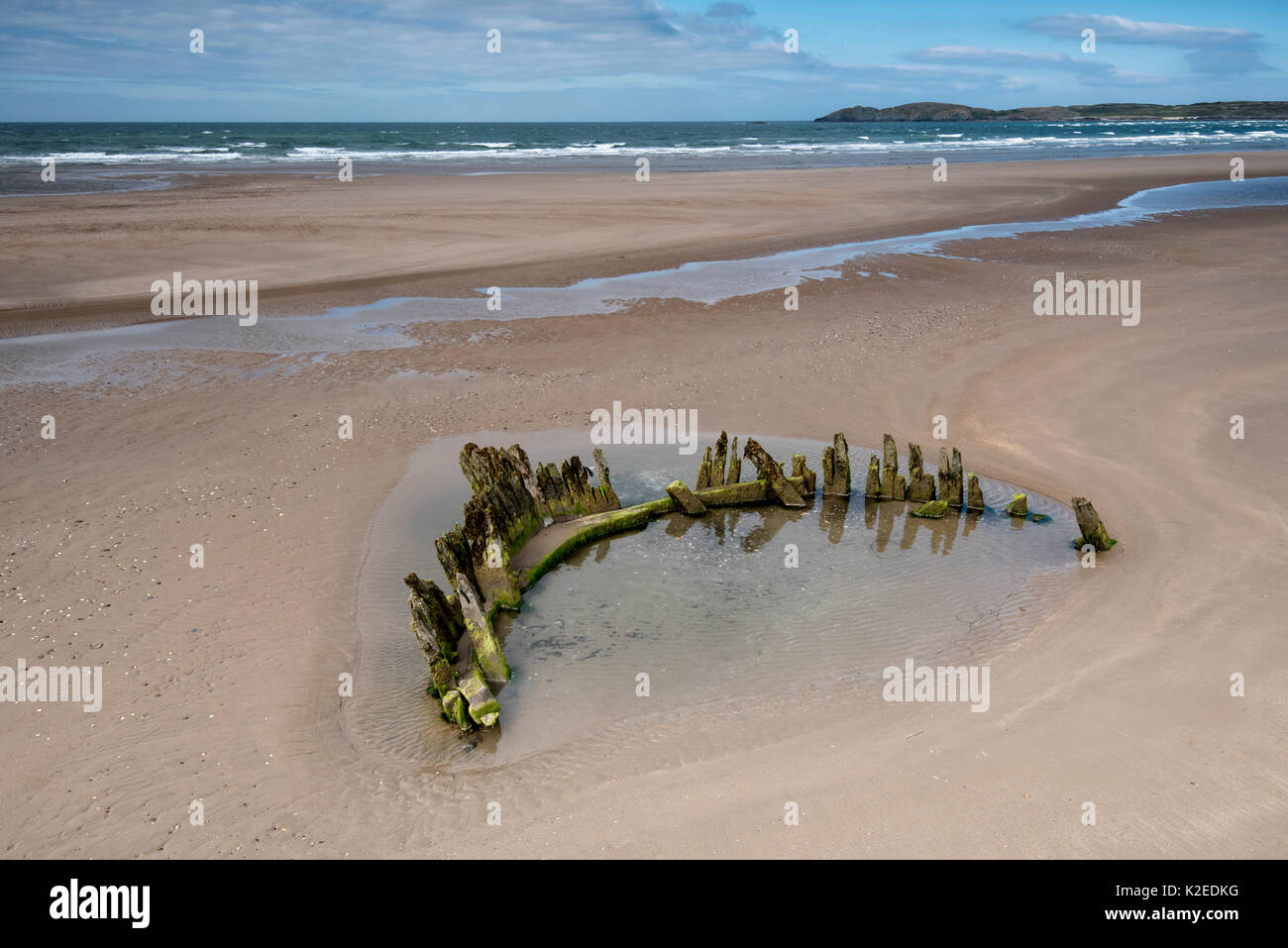 Wreck of the Brig Athena exposed at low tide on Malltraeth beach, Anglesey, North Wales, with Llanddwyn Island and Snowdonia in the background, UK August 2016. Stock Photo