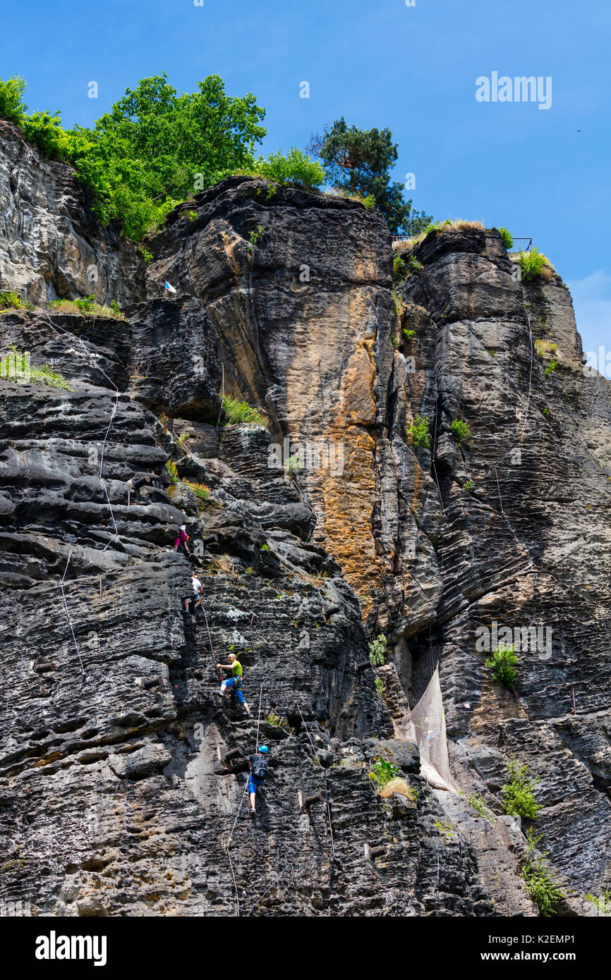 People climbing up cliffs on a  Via Ferrata, Bohemian Switzerland National Park, Decin Town, Elba River, Czech Republic, May 2016. Stock Photo