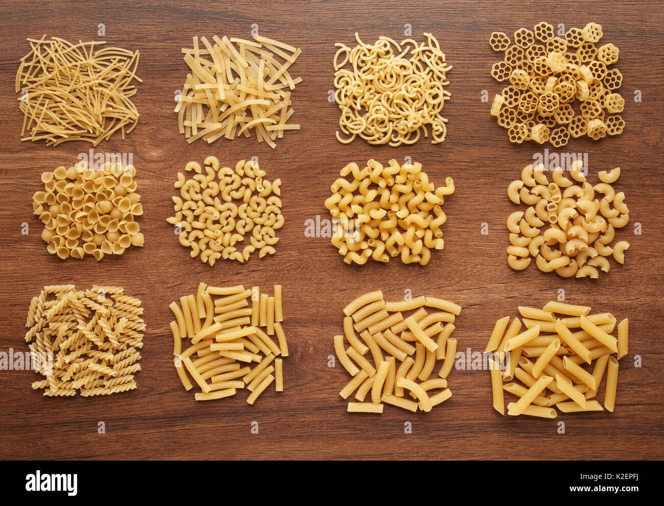Close up of several types of dry pasta on dark wooden table, top view Stock Photo