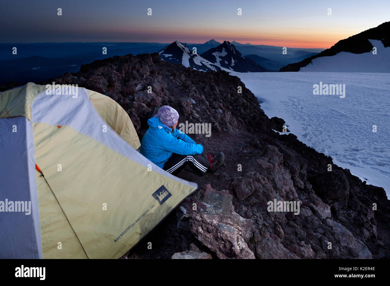 Woman camping on the crater rim of South Sister, Three Sisters Wilderness, Deschutes National Forest.  Oregon, USA, July 2014. Model released. Stock Photo