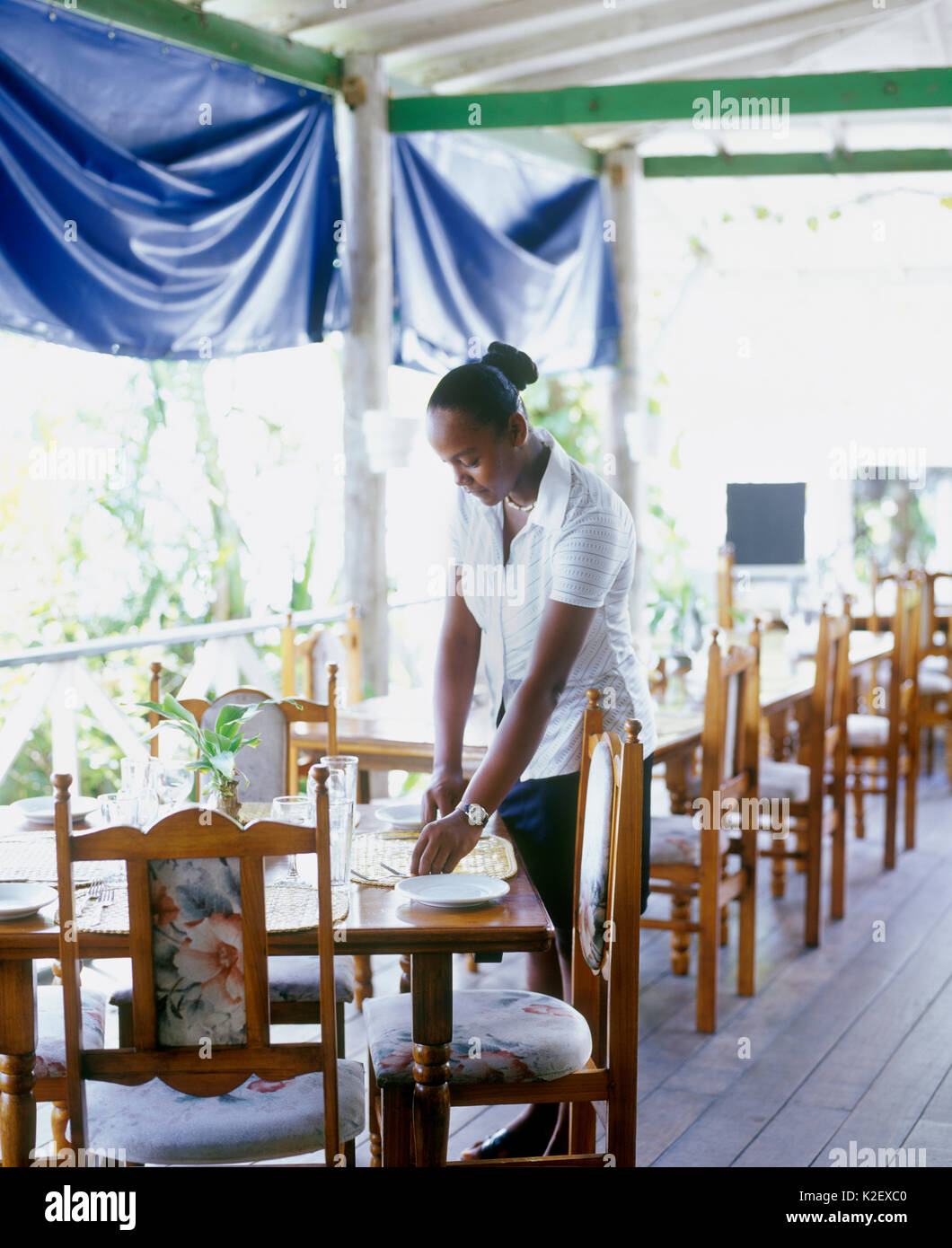 A waitress sets a table at the Lime N Pub. Kingstown, St. Vincent. West Indies. Stock Photo