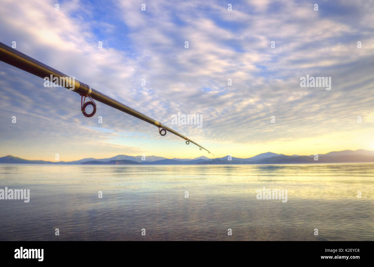 spinning - fishing rod on the summer lake Stock Photo