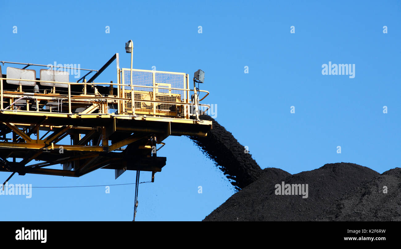 Yellow Coal Conveyor belt carrying coal and pouring onto a pile, Australia Stock Photo