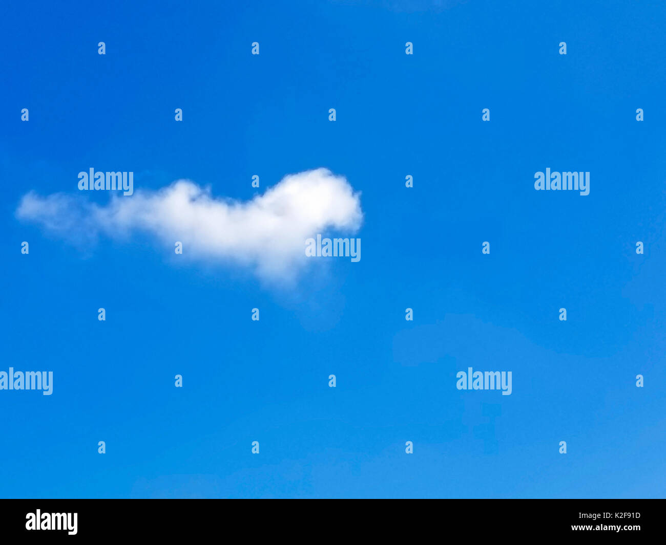 single white fluffy cloud in bright blue sky Stock Photo