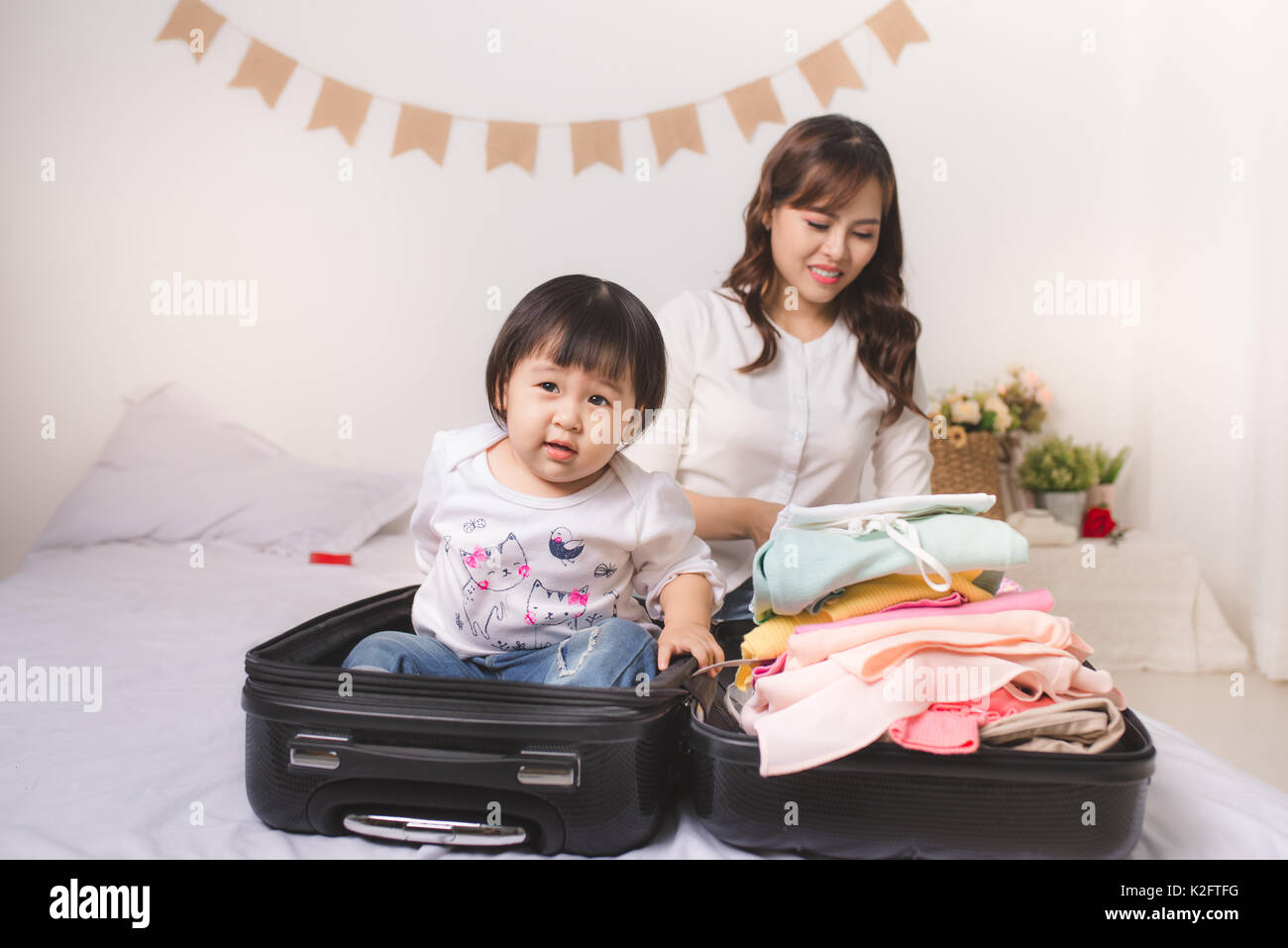 Asian mom e la bambina con la valigia bagaglio e vestiti pronto per  viaggiare in vacanza Foto stock - Alamy