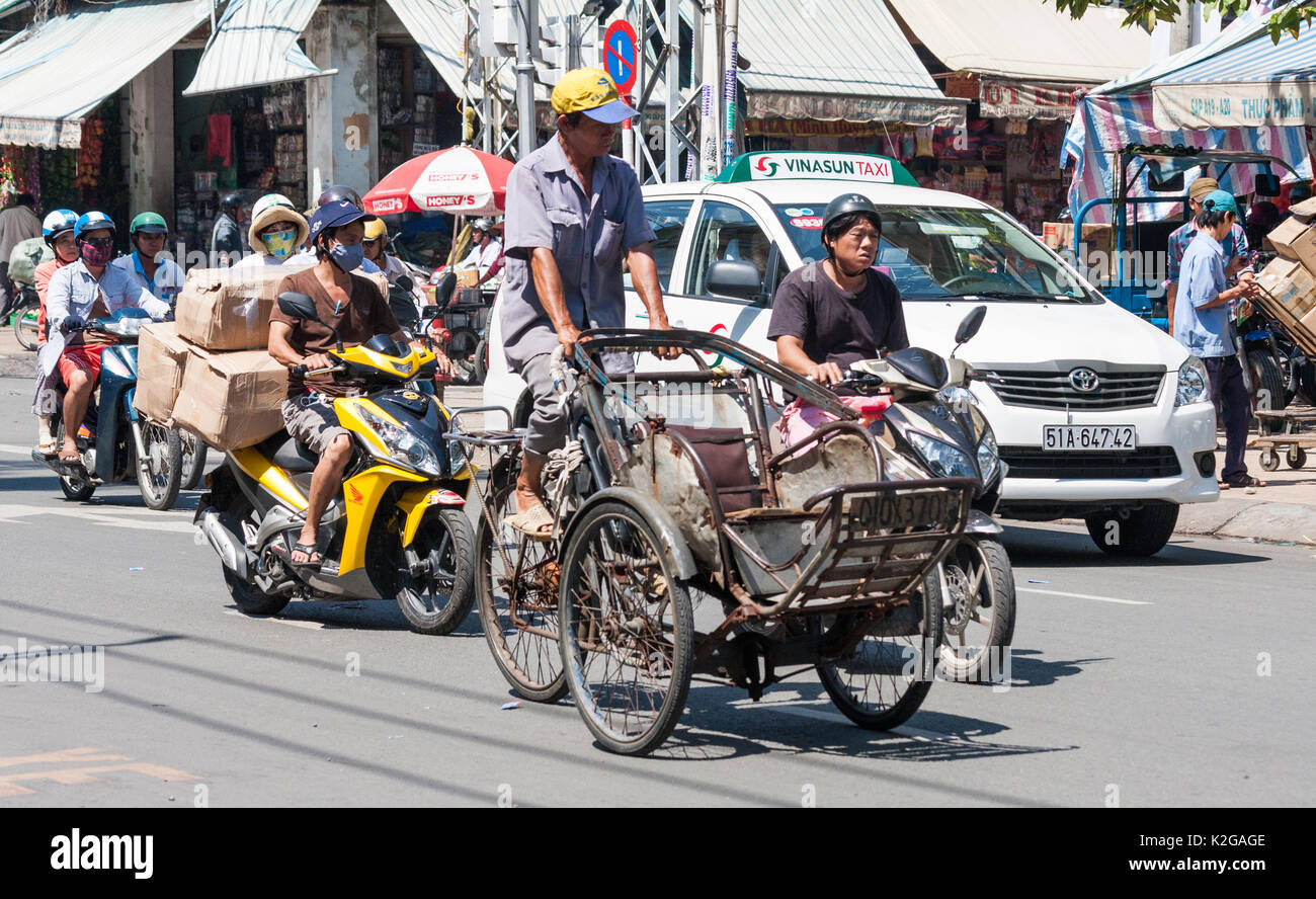 Rickshaw driver and other traffic in Cholon, Ho CHi Minh City (Saigon), Vietnam Stock Photo