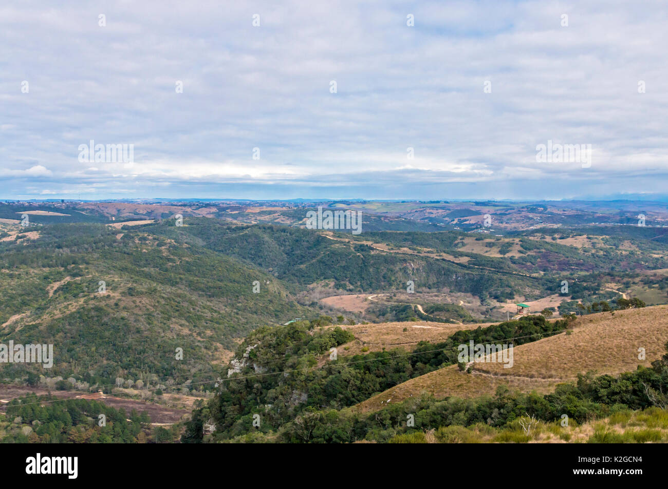 Dirt road winding through rural dry winter vegetation rocks hills and ...