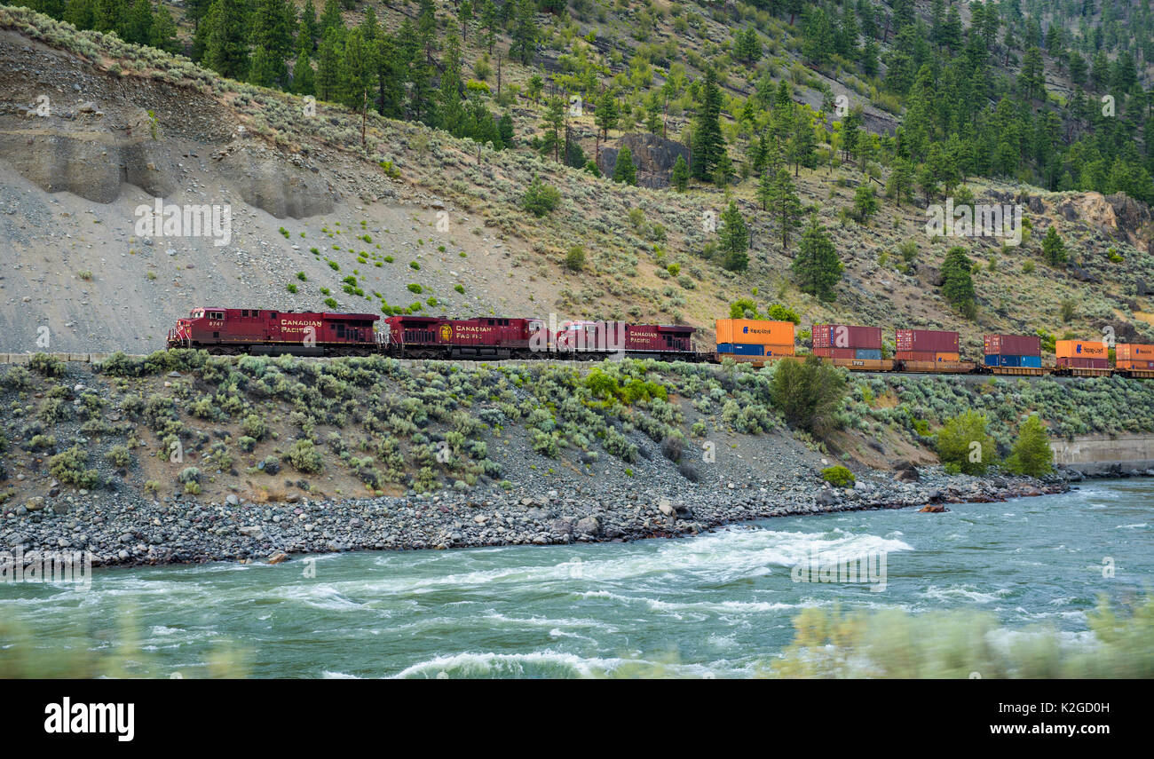 Freight train of Canadian Pacific Railway moving along the Thompson River. Stock Photo