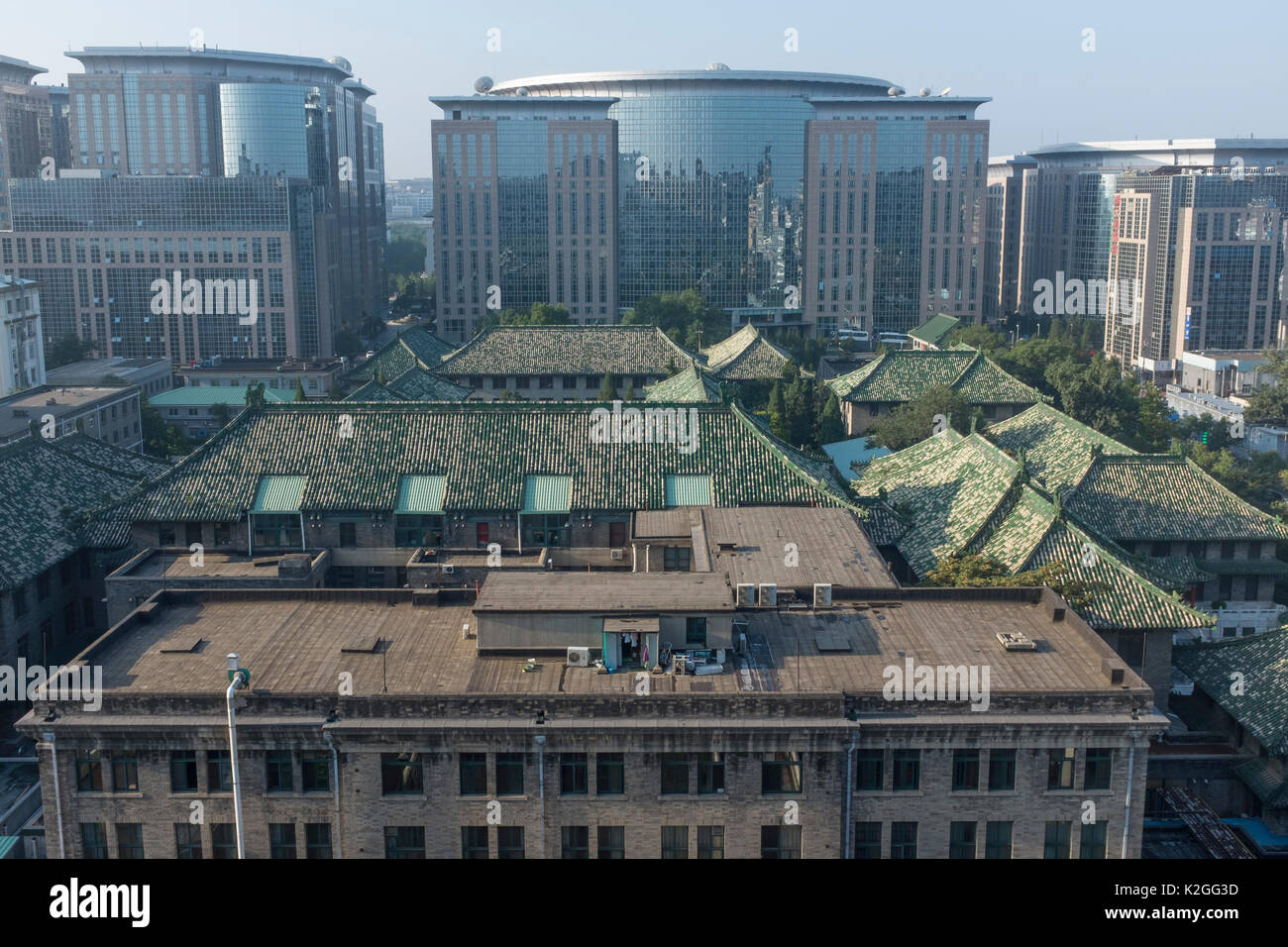 Historical glazed tile roof of Peking Union Medical College Hospital among  modern construction. Beijing, China. Stock Photo