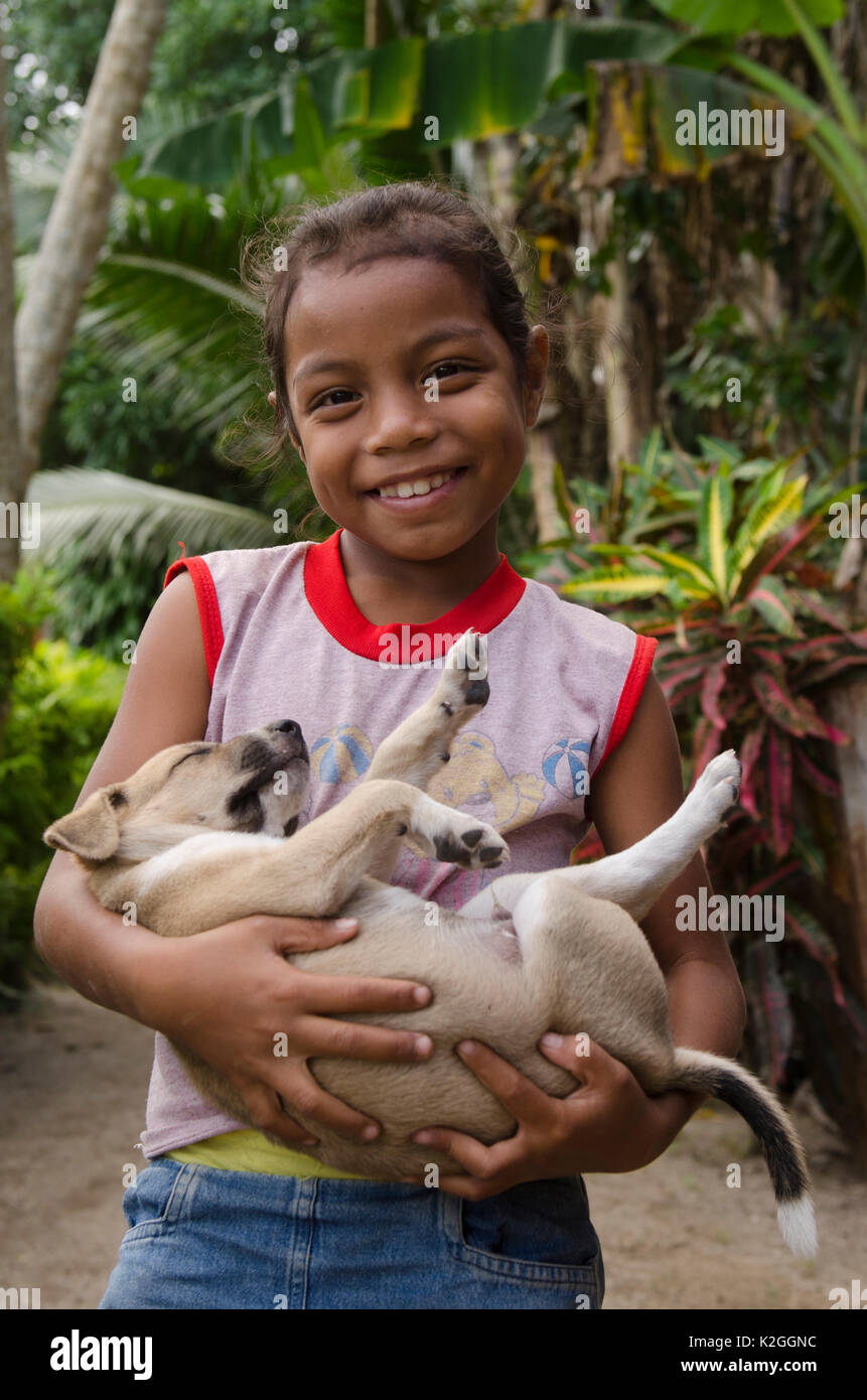 Local girl holding sleeping puppy, Kioa Island, Fiji, South Pacific, July 2014. Stock Photo