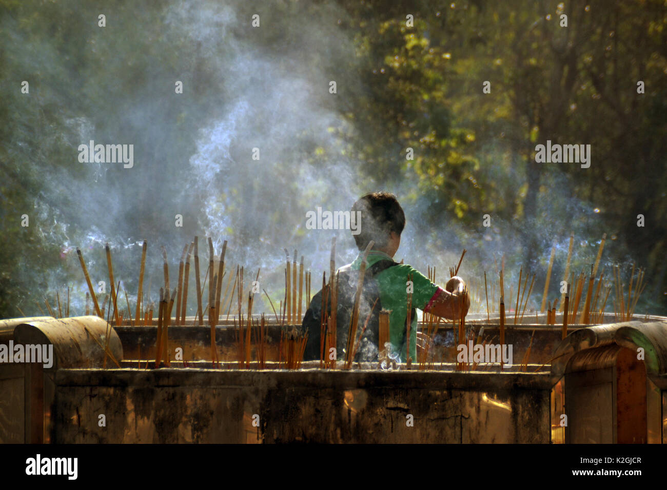 Young man put up incenses on Lamma Island temple Stock Photo