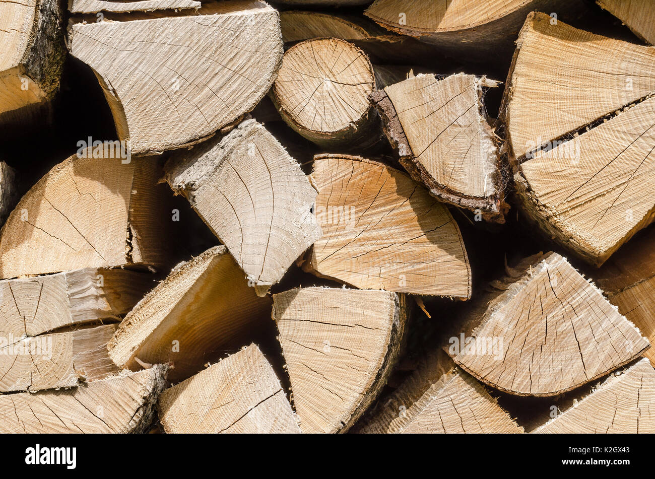 Splitted, dried and stacked firewood, horizontal front view. Stack of weathered, dry wood, a source of energy. Photo. Stock Photo