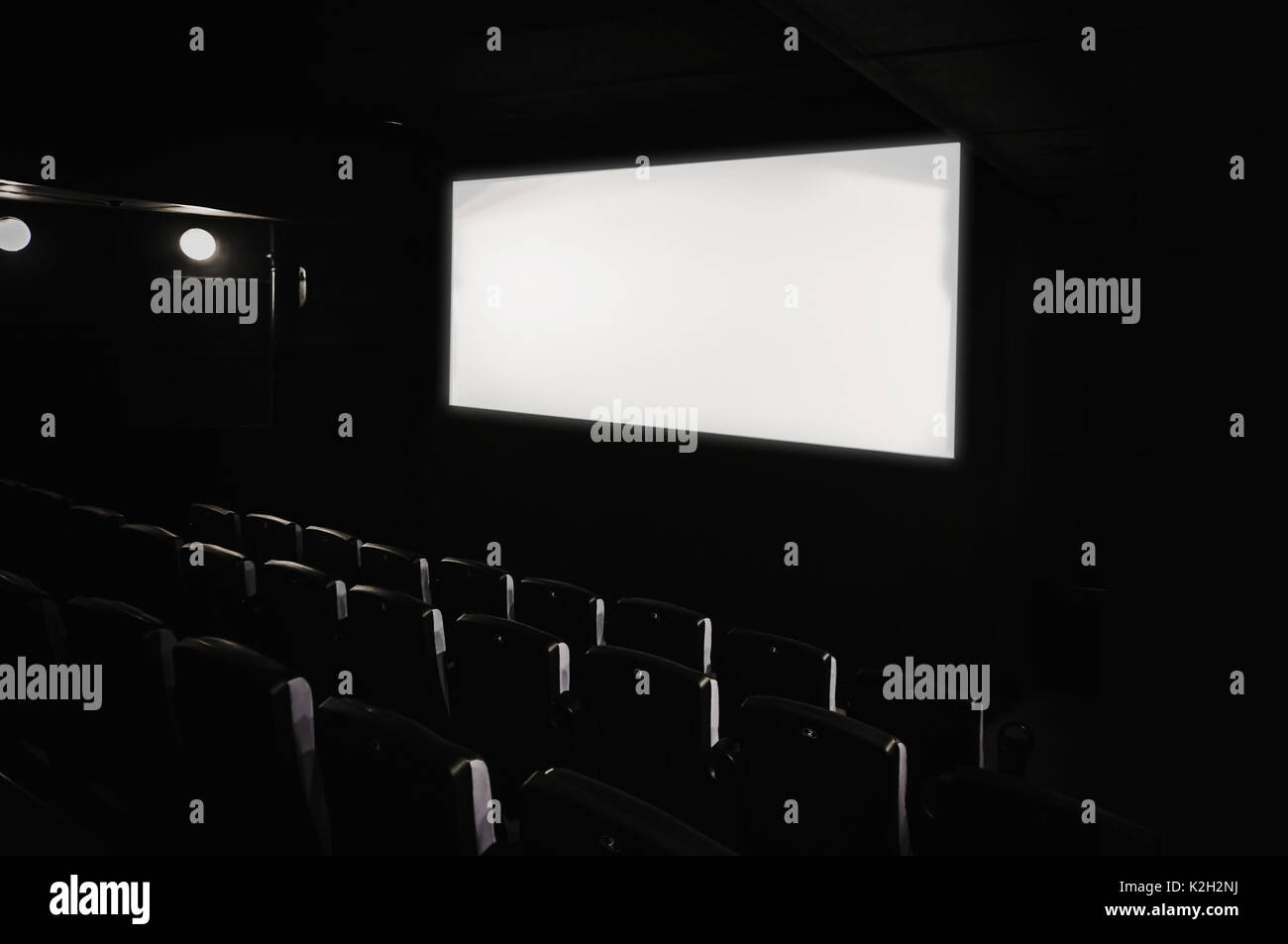 Dark movie theatre interior. tilted screen, chairs Stock Photo