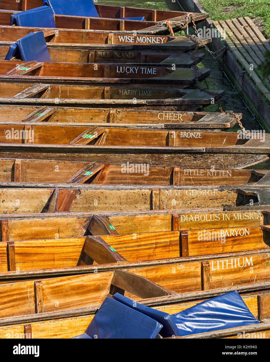 CAMBRIDGE, UK - AUGUST 11, 2017:  Punts moored to the bank by Trinity College with appropriately scholarly names Stock Photo