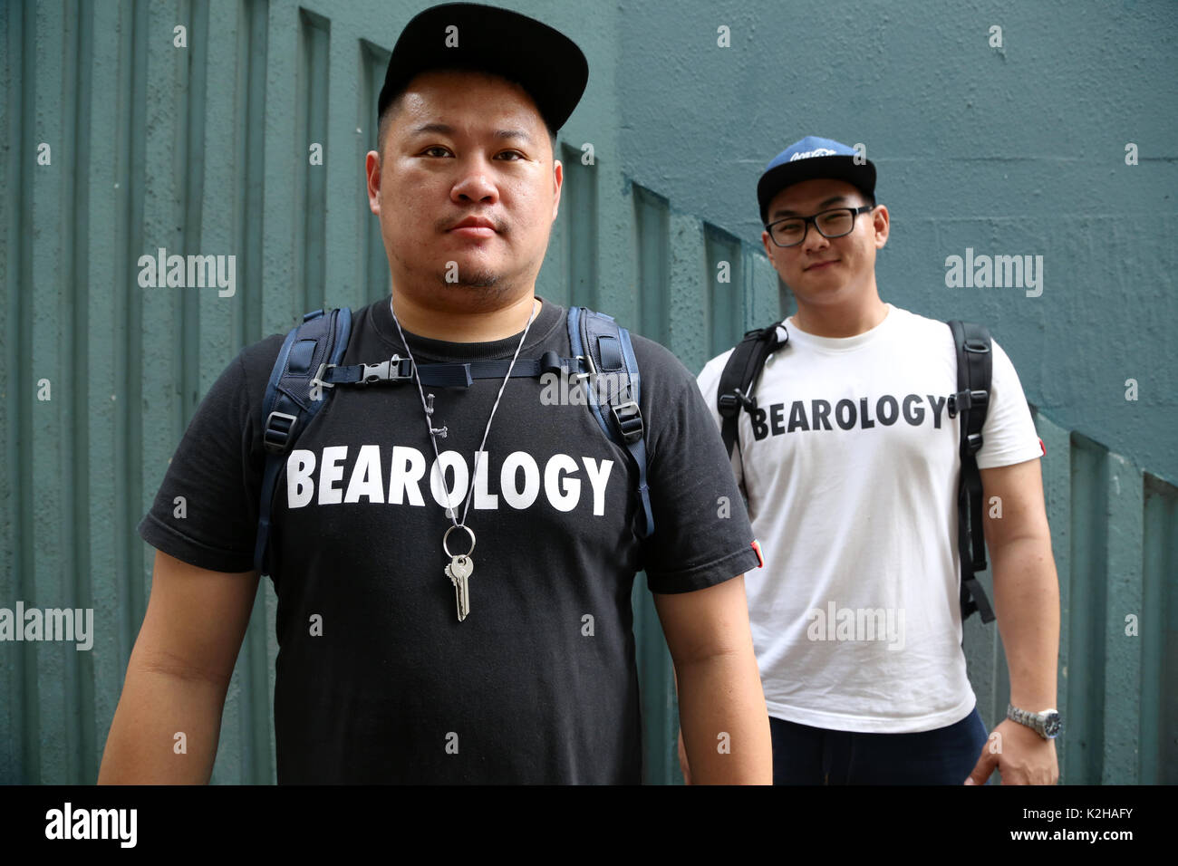 Two gay men in the streets of Hong Kong, Bear style with cap Stock Photo