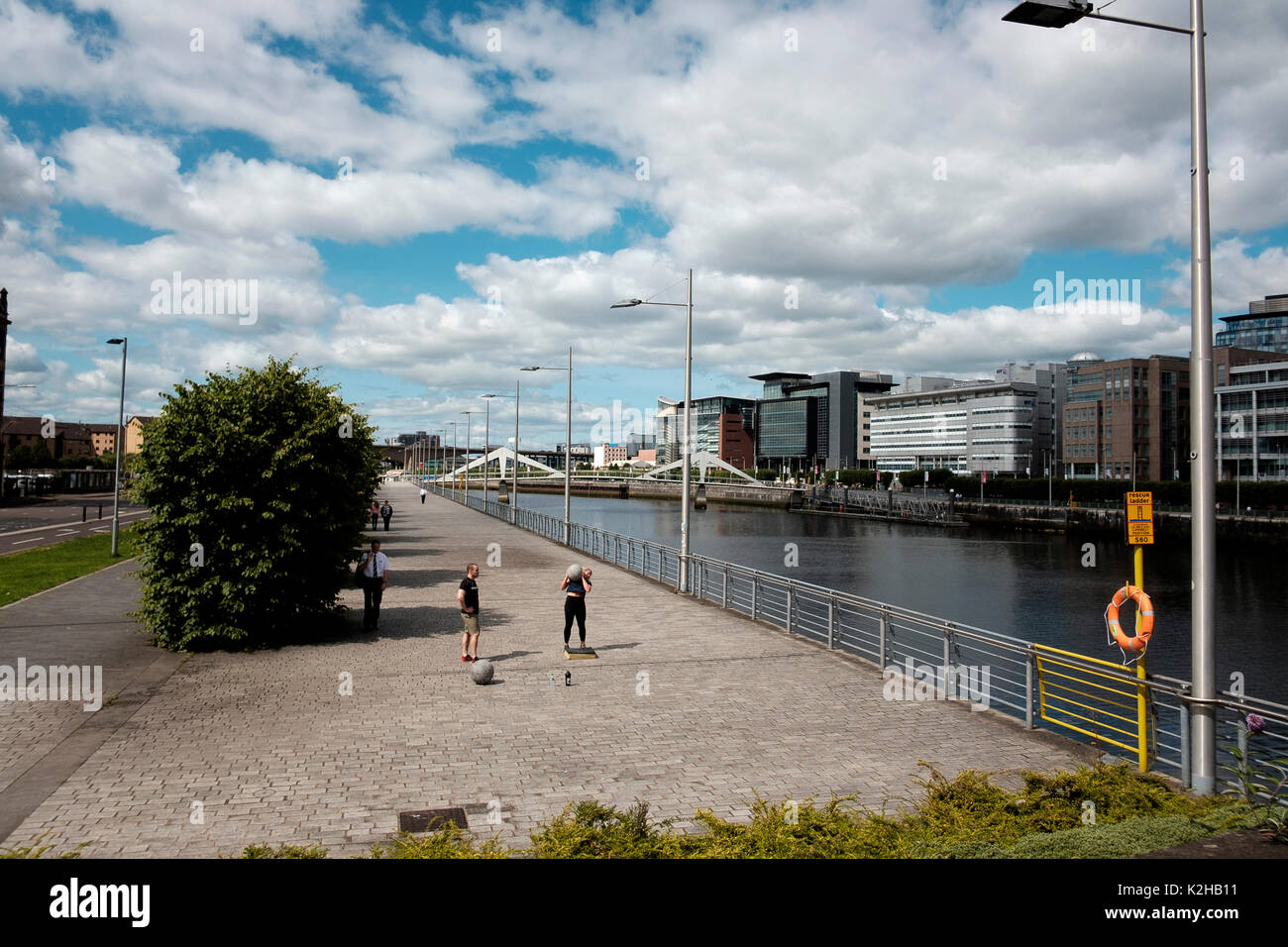 The boardwalk at Clyde Place opposite modern architectural development on Broomielaw on the banks of the River Clyde in Glasgow, Scotland Stock Photo
