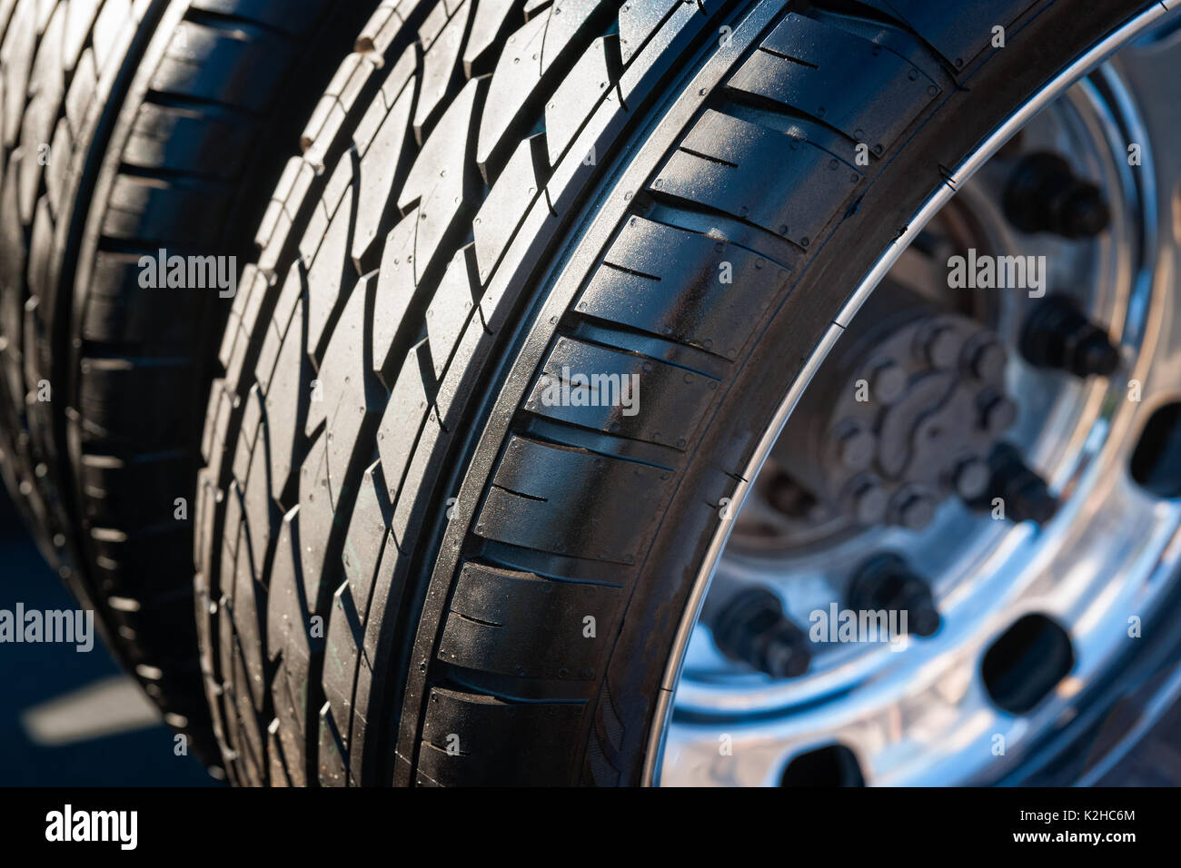 Closeup view of a dual tire wheel of a modern sports car. Black rubber