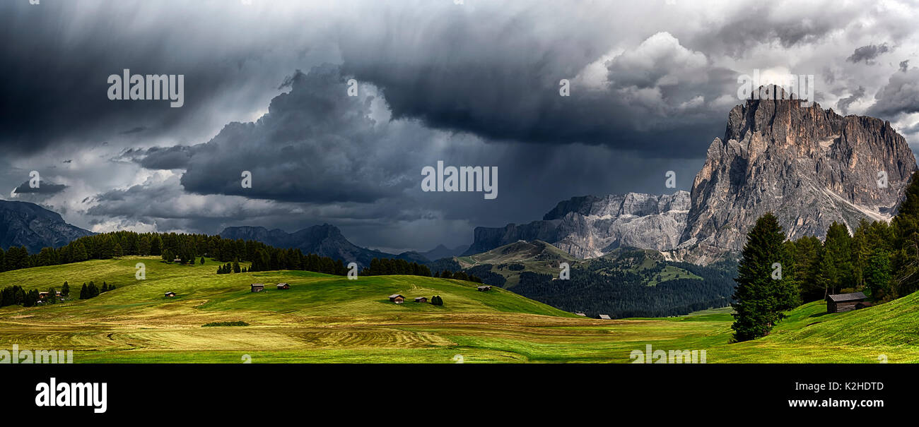 storm over the mountains Dolomiti in the summer season with green meadow illuminated of the Sun - Seiser Alm, Trentino-Alto Adige Stock Photo