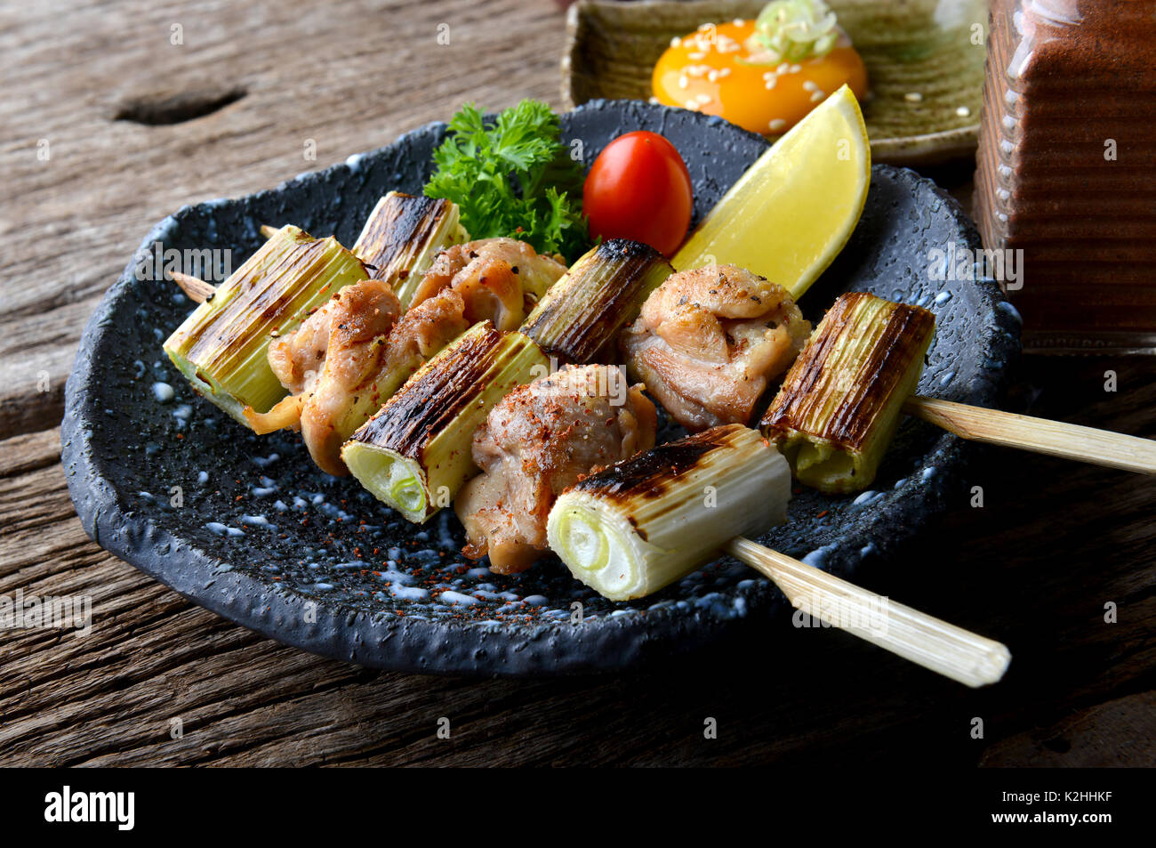 Nekima yakitori or Japanese chicken and onion in bamboo skewer grilled with charcoal fire serve in izakaya reataurant. Stock Photo