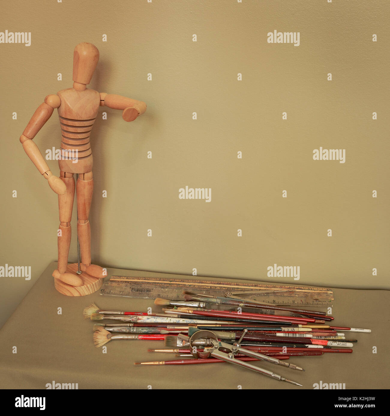 Art mannequin displayed beside art supplies, copy space Stock Photo
