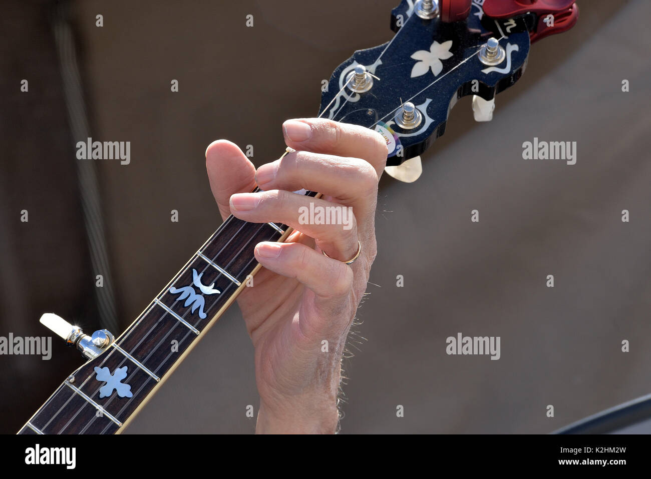 Banjo player hand on  fingerboard Stock Photo