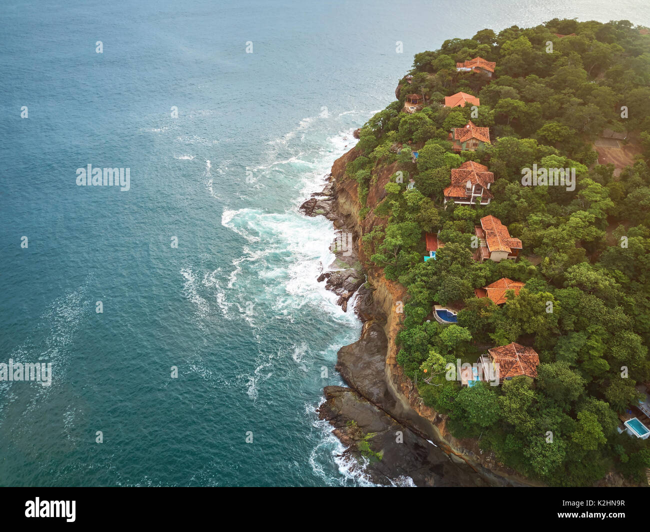 Houses in shore cliff aerial drone view on sunny day Stock Photo